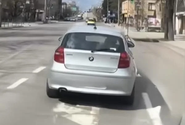 Срібний автомобіль їде по міській вулиці