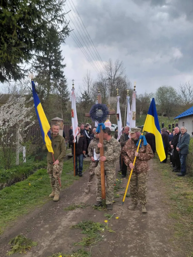 Військові несуть українські прапори на церемонії