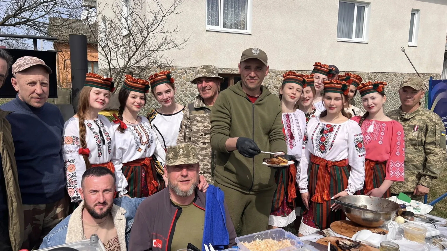Військові та дівчата у вишиванках святкують на подвір’ї