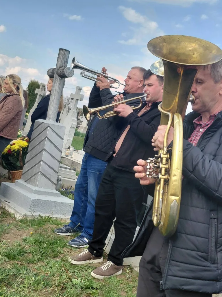 Музиканти грають духові інструменти на цвинтарі