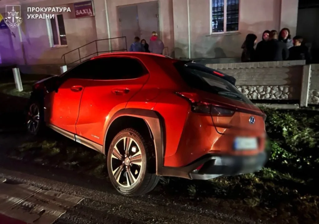 Червоний автомобіль після ДТП біля будівлі