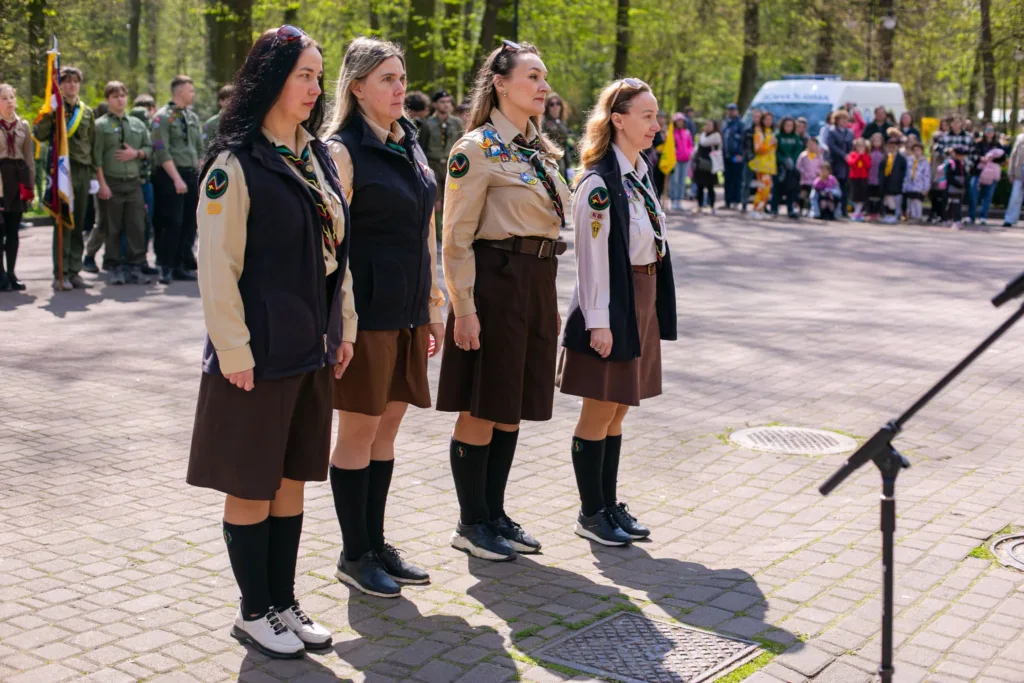 Жінки-скаути стоять під час церемонії на природі