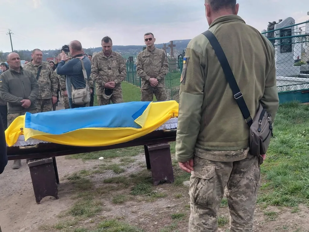 Військові прощаються із загиблим героєм під прапором України