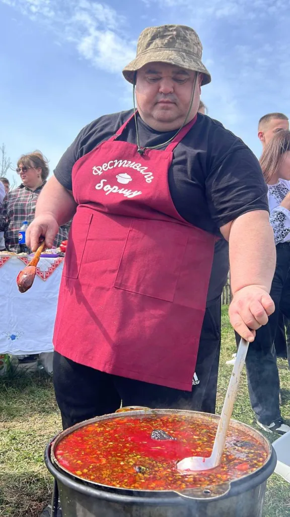 Чоловік готує борщ на фестивалі просто неба