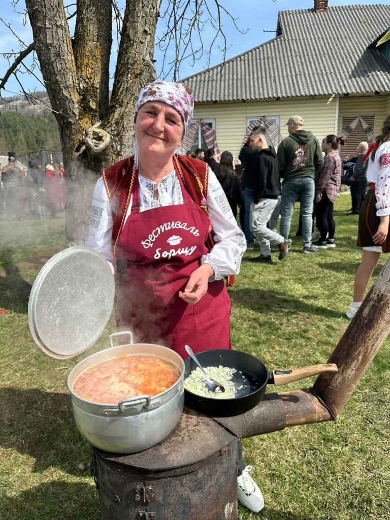 Жінка готує борщ на фестивалі просто неба