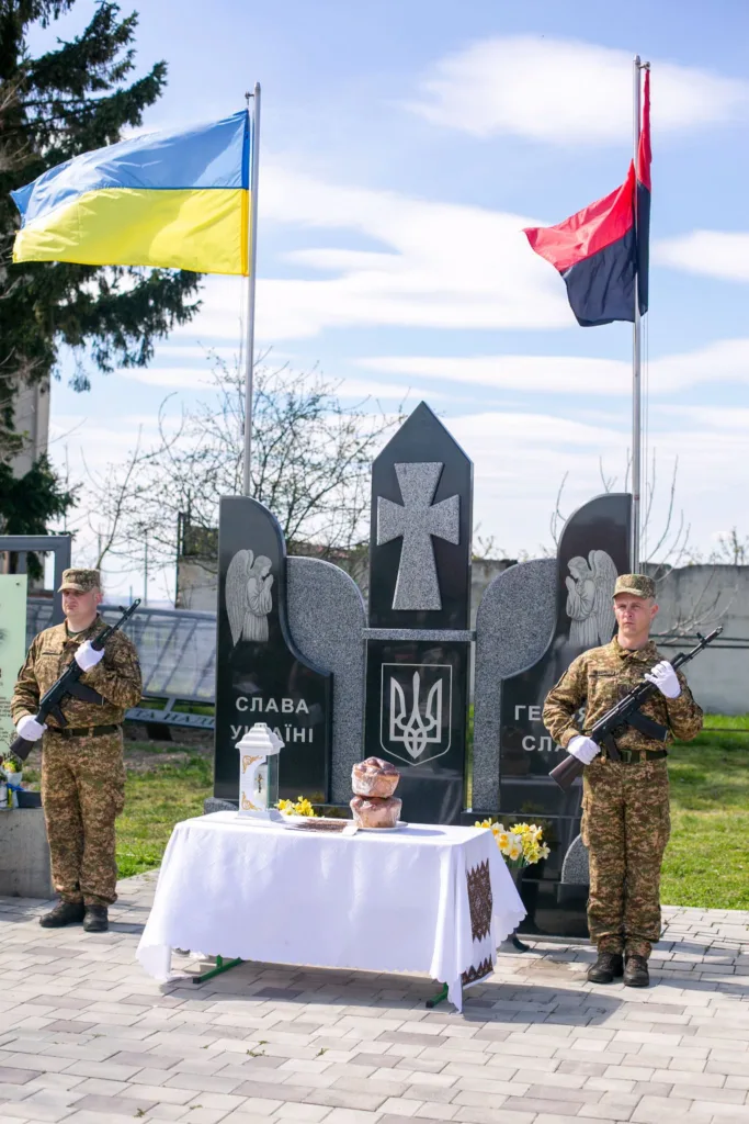 Військові стоять біля меморіалу Героям України