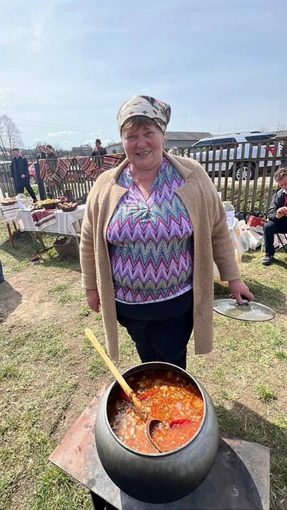 Жінка готує борщ на відкритому повітрі