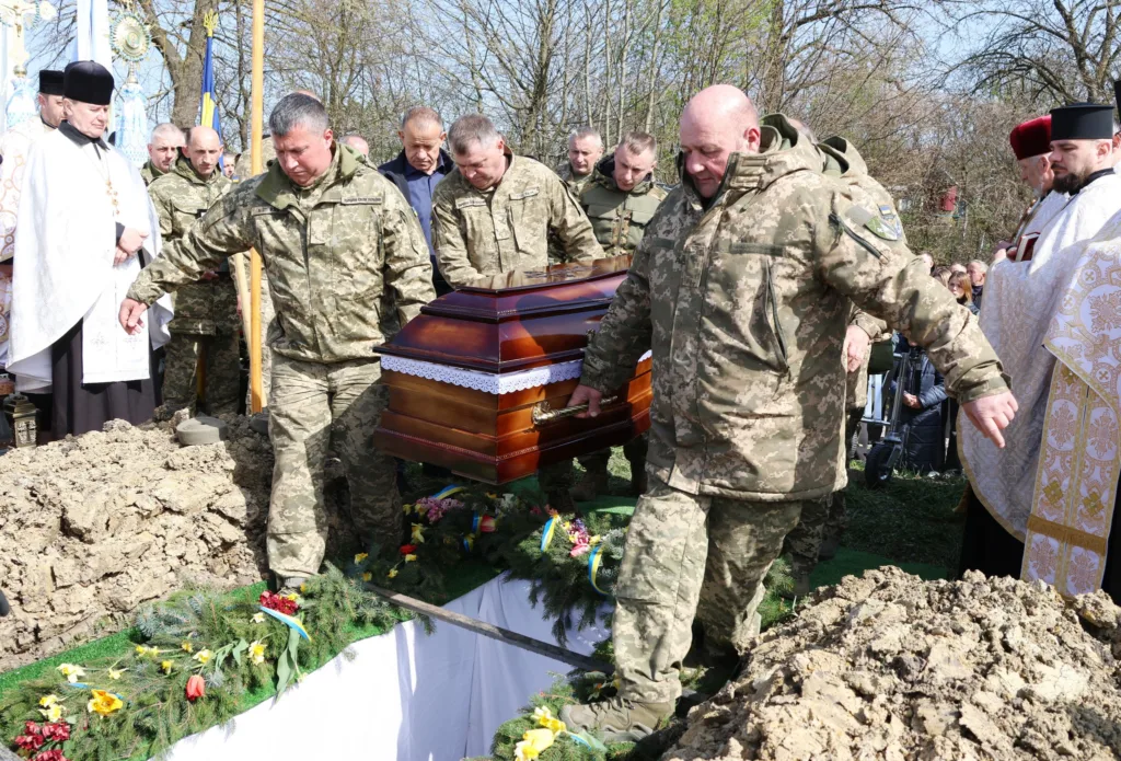 Військові несуть труну на похороні захисника України