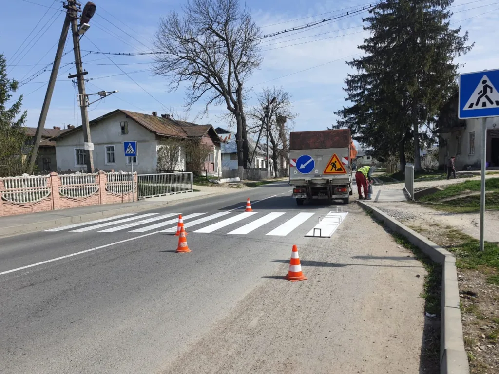 Робітники наносять розмітку пішохідного переходу