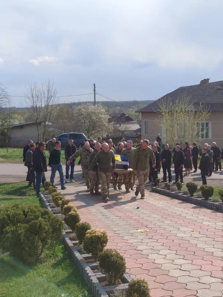 Військові несуть труну під українським прапором