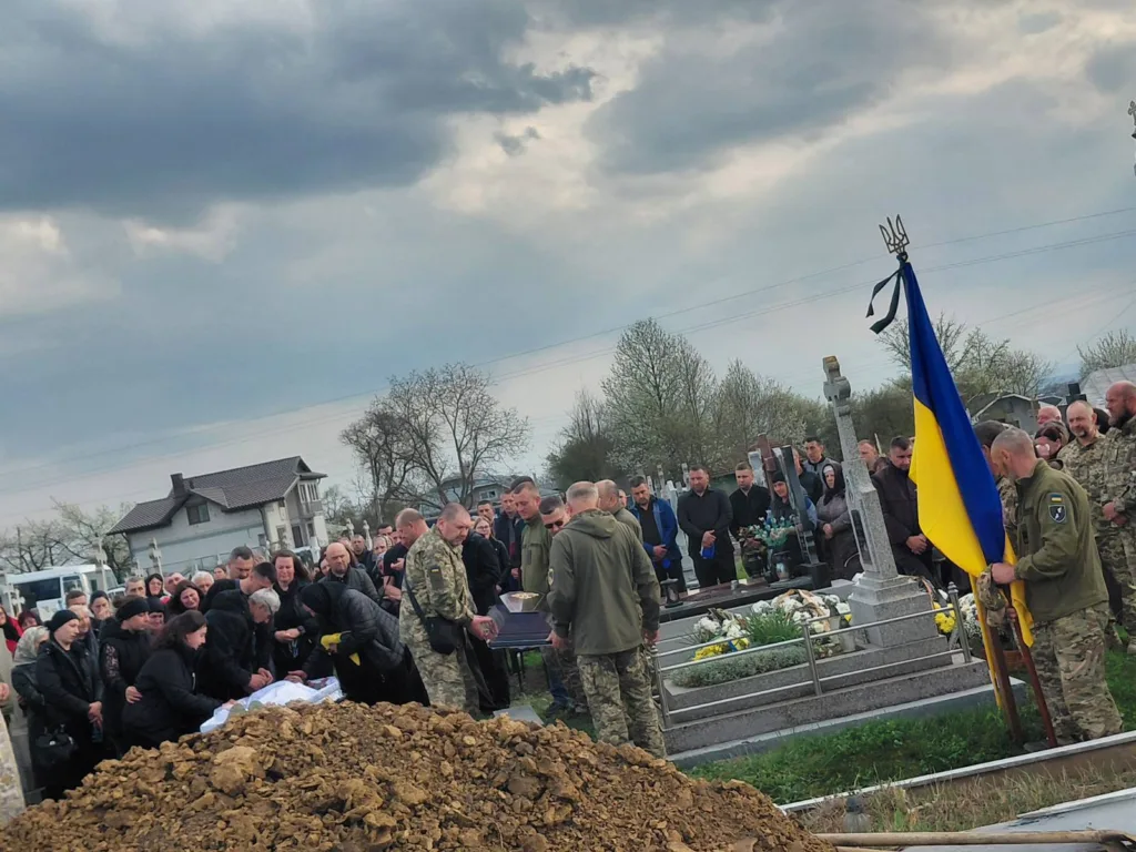 Похорон військового з українським прапором на цвинтарі