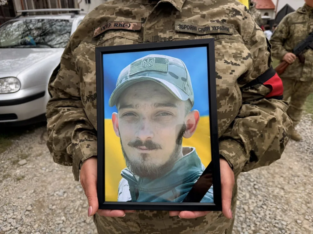 Військовий тримає портрет загиблого героя України