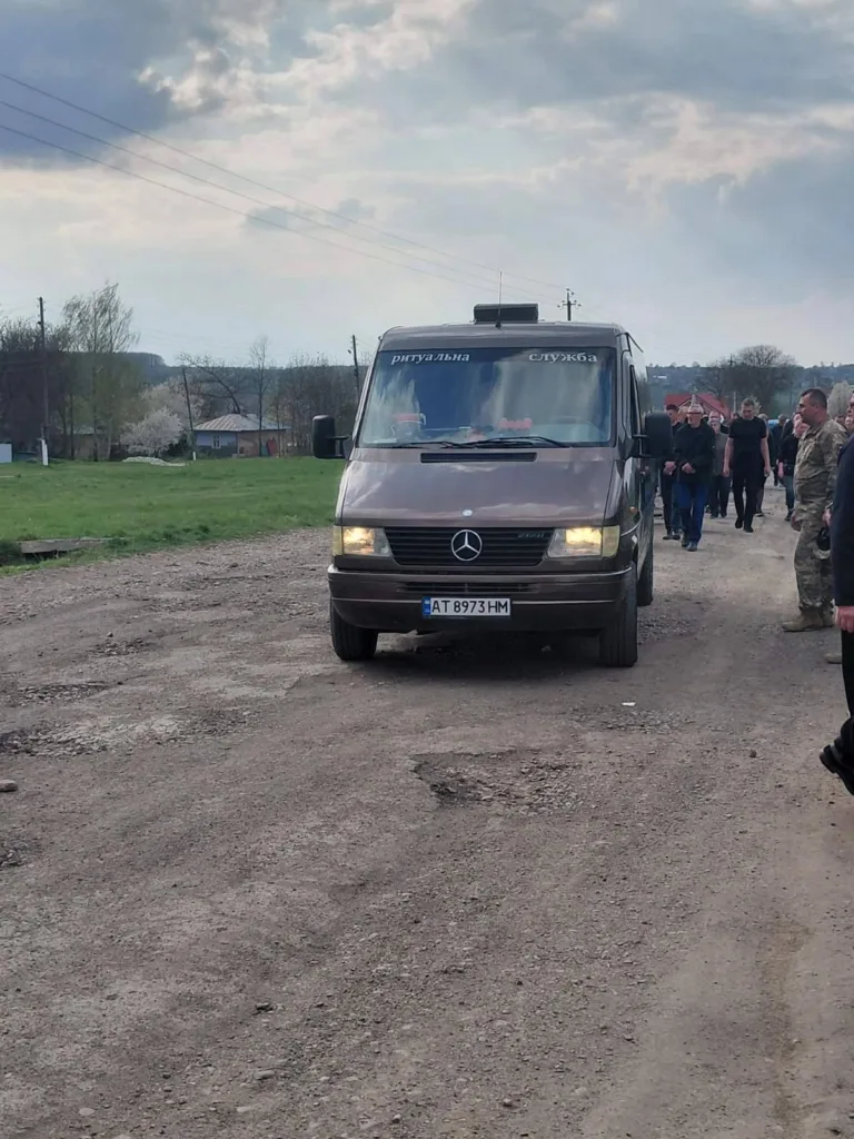 Ритуальний автомобіль на сільській дорозі з людьми