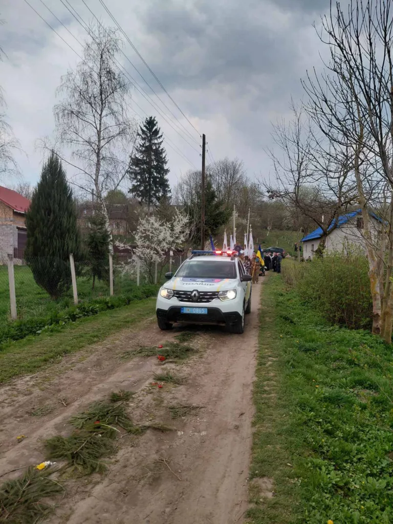 Поліцейський автомобіль на сільській дорозі з прапорами