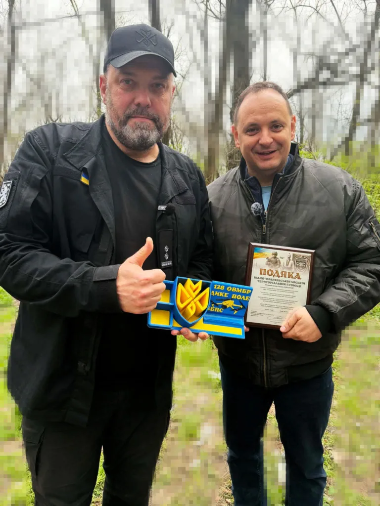 Двоє чоловіків тримають нагороду та подяку