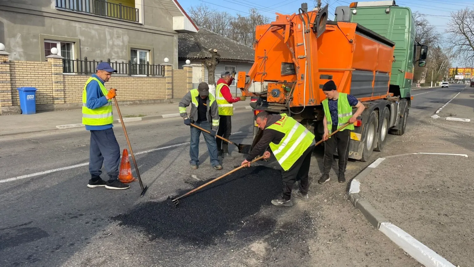 Робітники ремонтують дорожнє покриття асфальтом