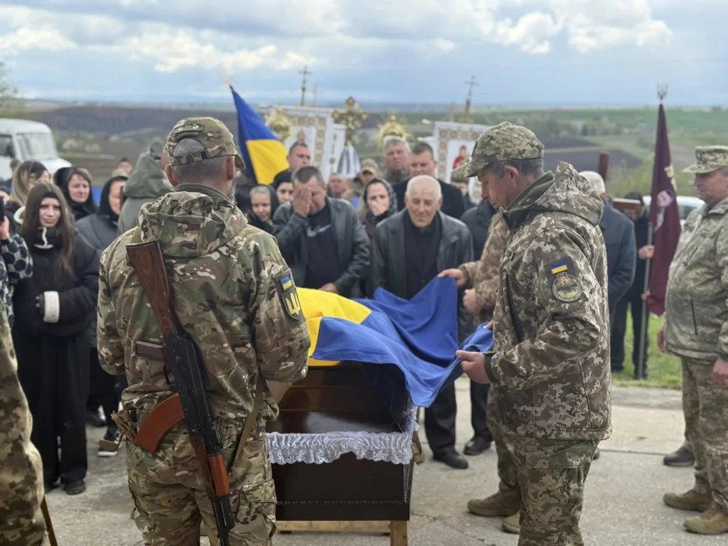 Військові проводять похорон із українським прапором