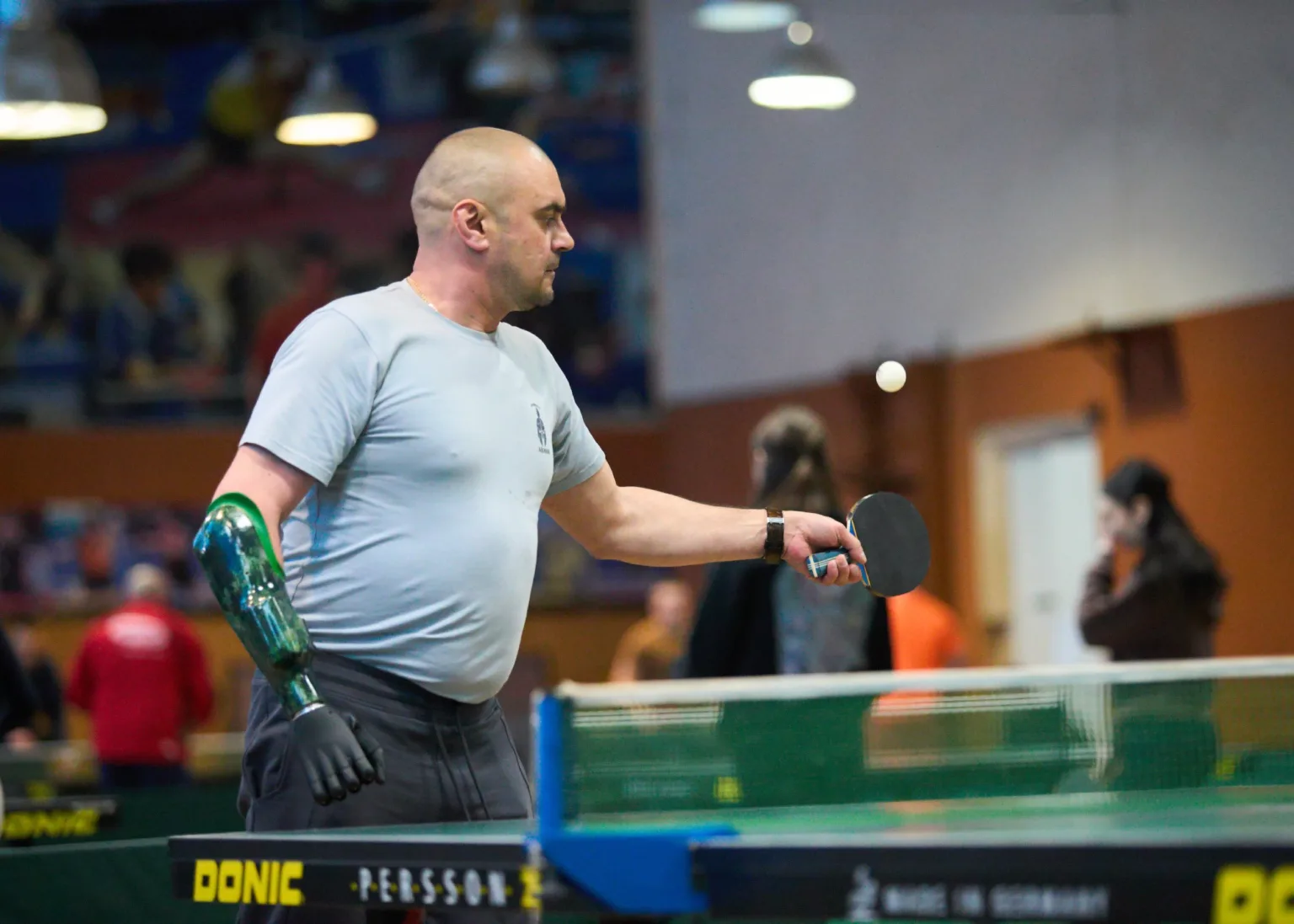 Чоловік грає у настільний теніс з протезом руки