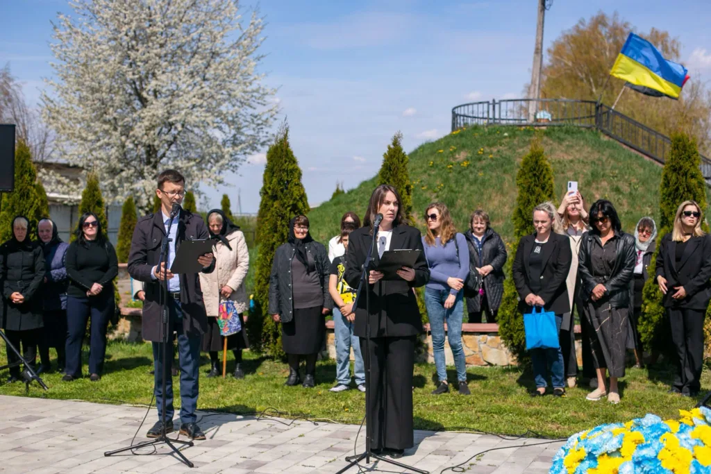 Люди виступають на вуличній церемонії з прапором України