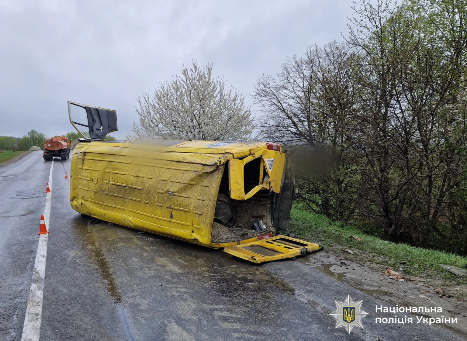Перекинута жовта вантажівка на узбіччі дороги