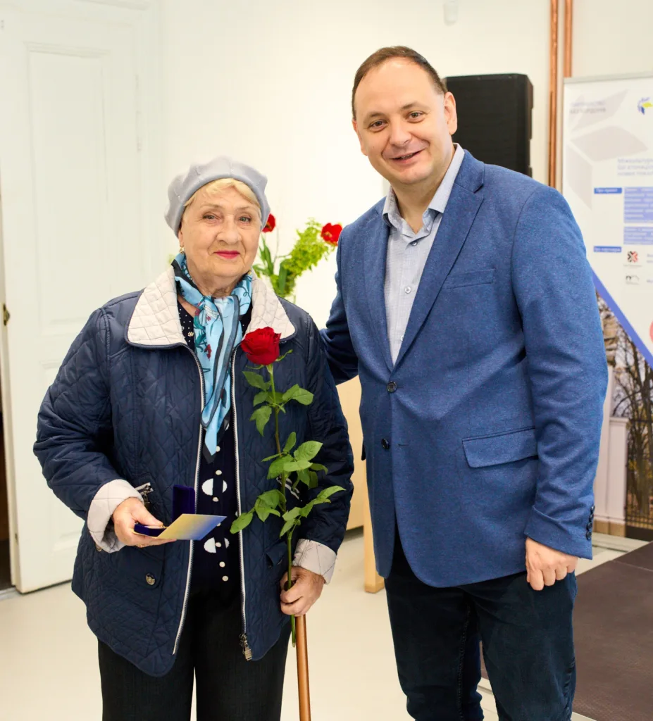 Жінка отримує квітку під час церемонії нагородження