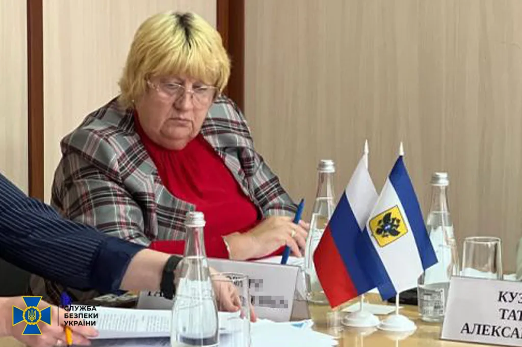 Жінка на нараді з російськими прапорами