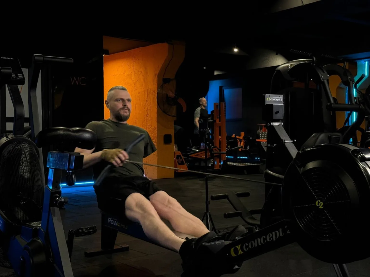 Чоловік тренується на весловому тренажері у спортзалі