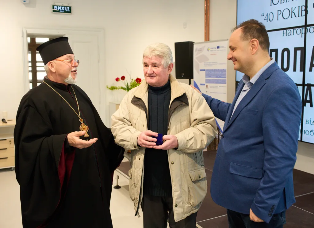 Троє чоловіків спілкуються під час урочистого заходу