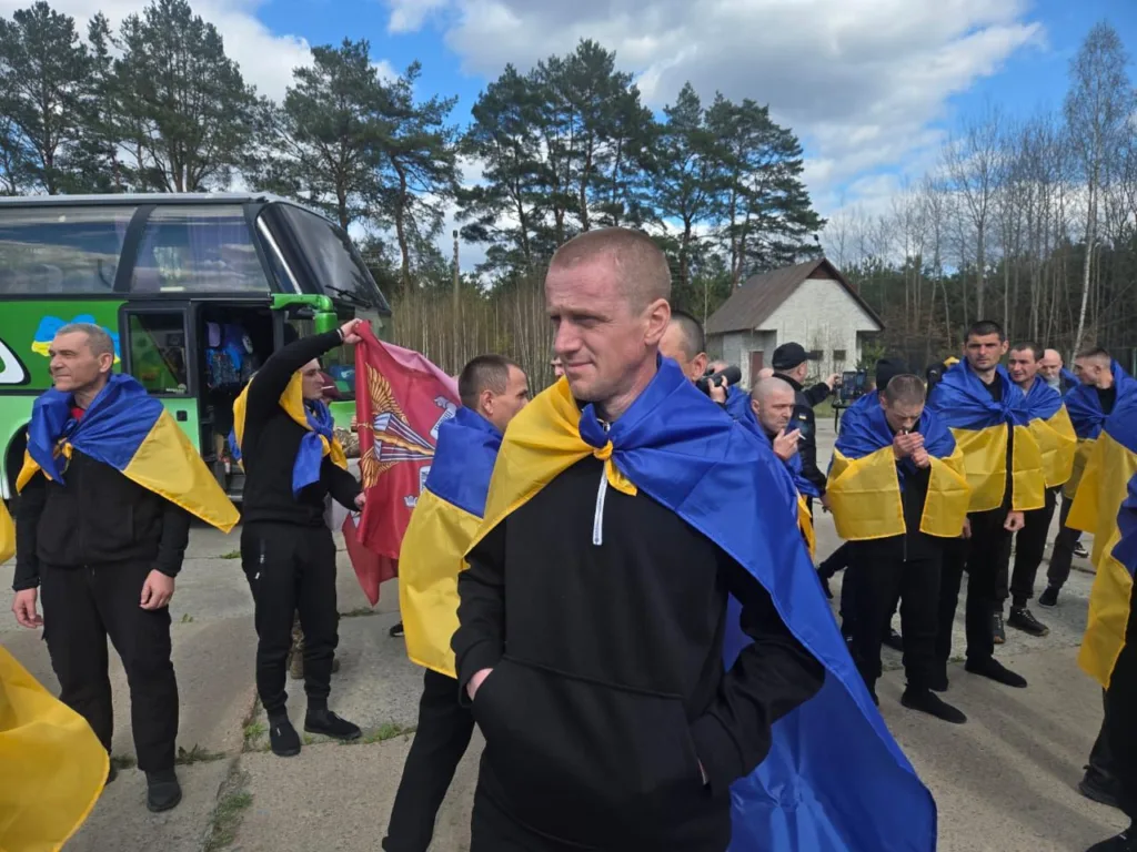 Військові з українськими прапорами біля автобуса