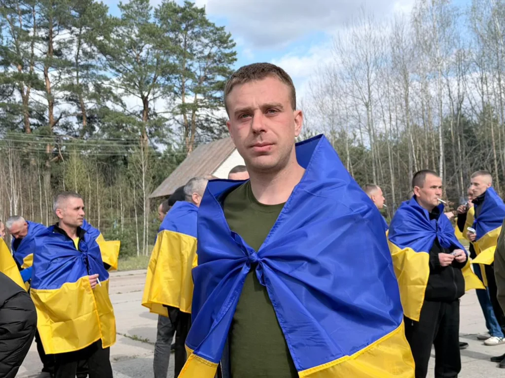 Люди загорнуті в прапори України на вулиці