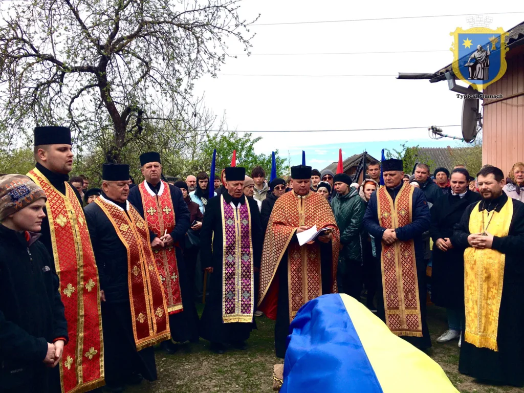 Священики проводять похорон під українським прапором