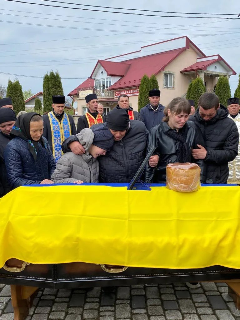 Похорон з українським прапором та скорботними людьми