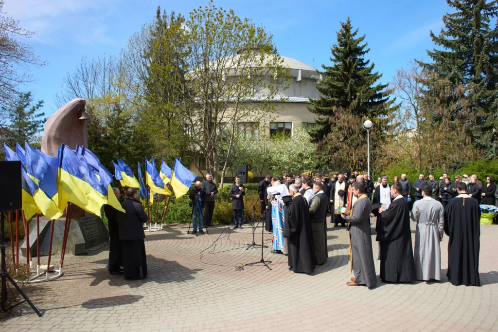 Молитва біля пам'ятника з українськими прапорами