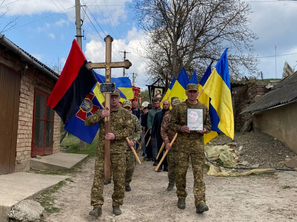 Військові України несуть прапори та хрест