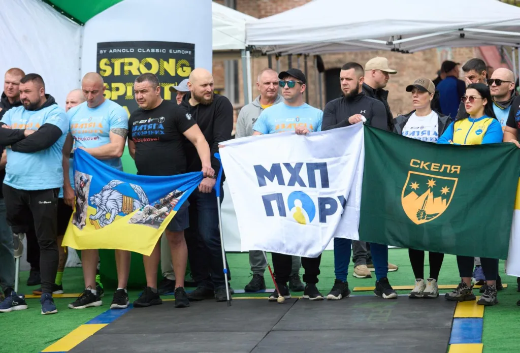 Спортсмени тримають українські прапори на змаганнях