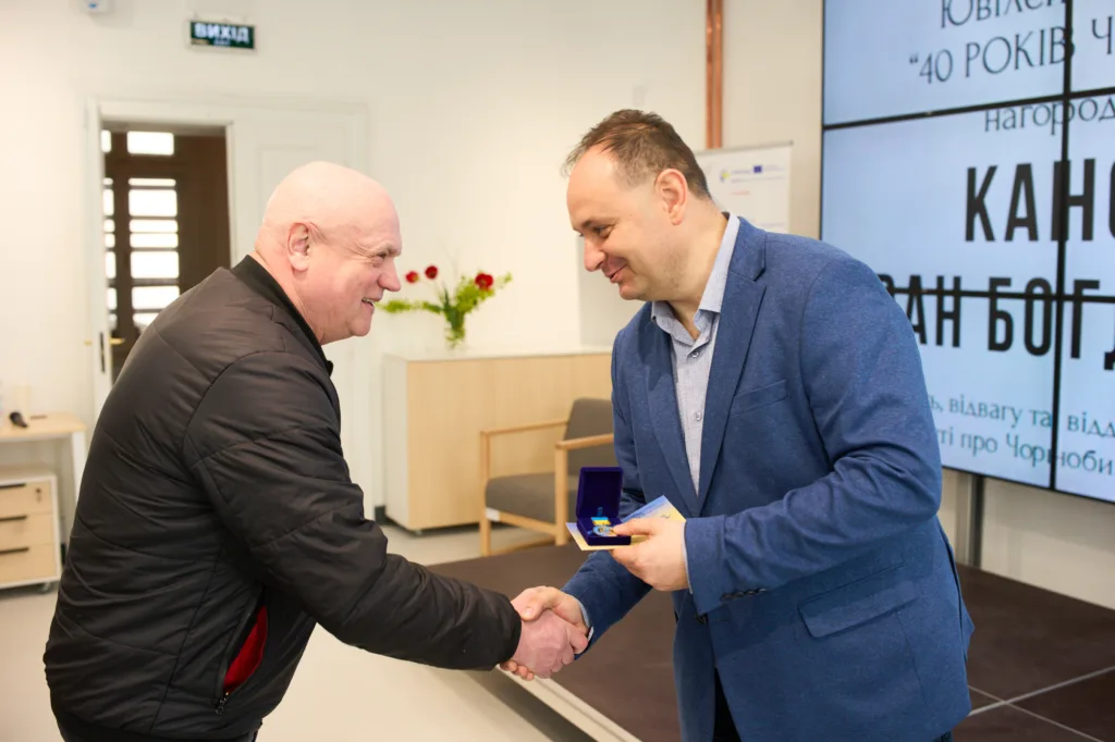 Вручення нагороди чоловіком у синьому піджаку