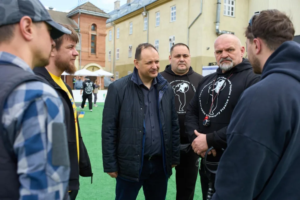 Група чоловіків спілкується на вулиці біля будівель