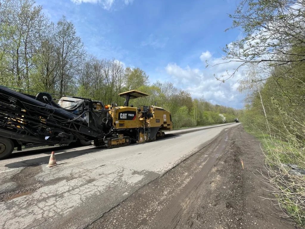 Ремонт дороги асфальтоукладальником біля лісу