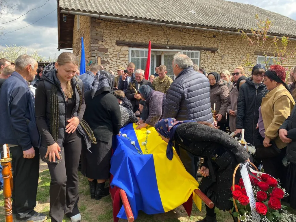 Похорон воїна з українським прапором та людьми