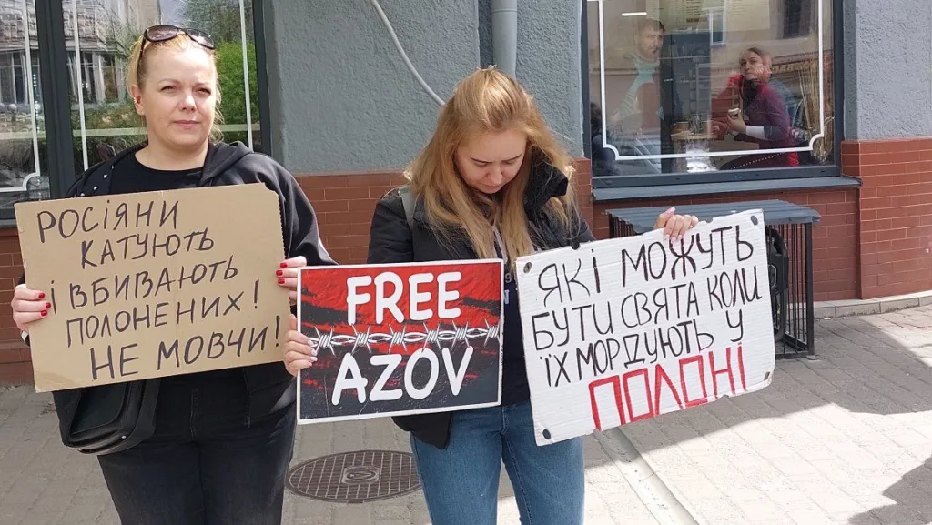 Жінки тримають плакати на протесті за Азов.