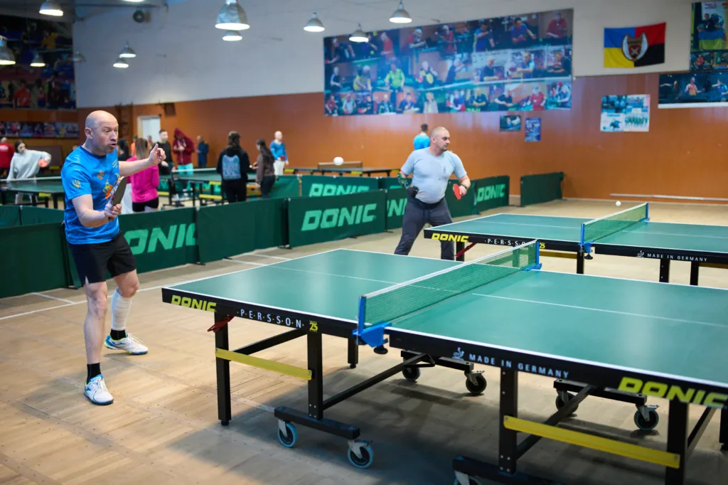 Чоловіки грають у настільний теніс у спортзалі