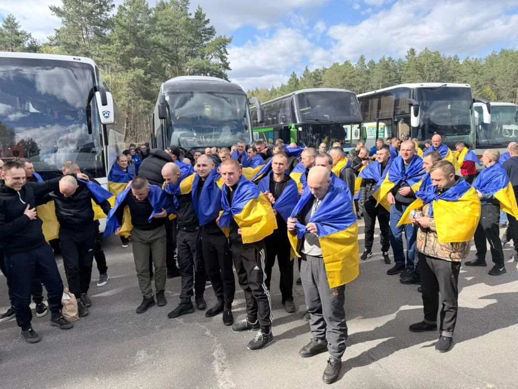 Люди з українськими прапорами біля автобусів