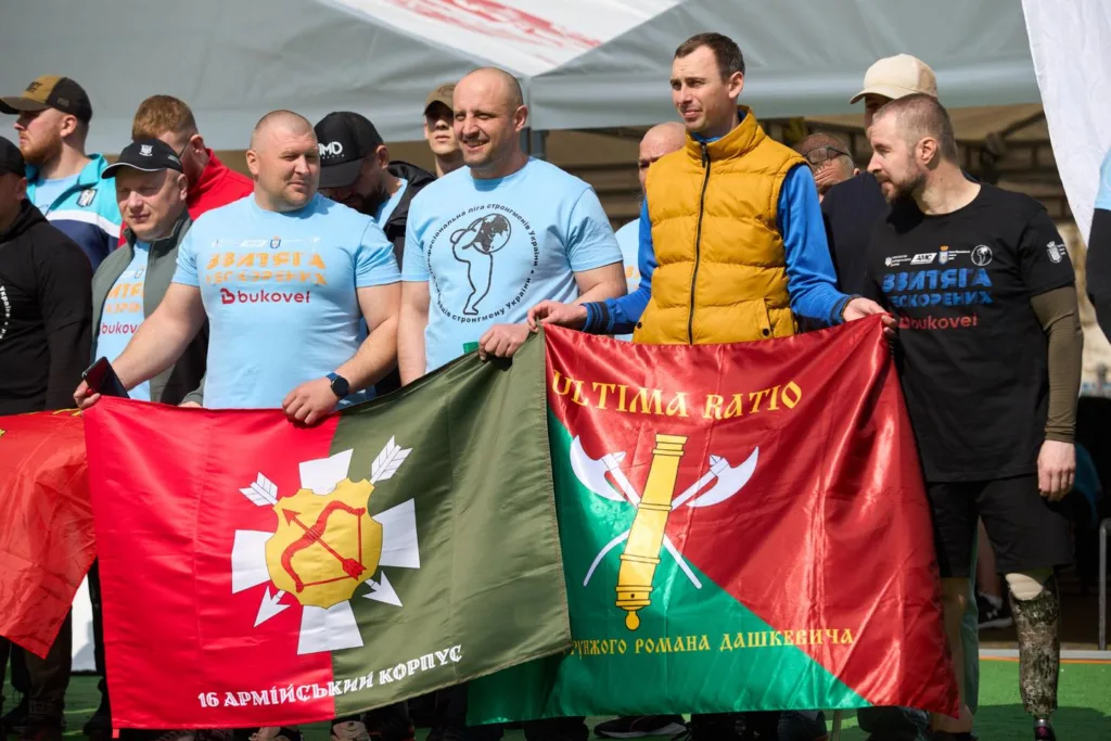 Учасники заходу тримають військові прапори на вулиці