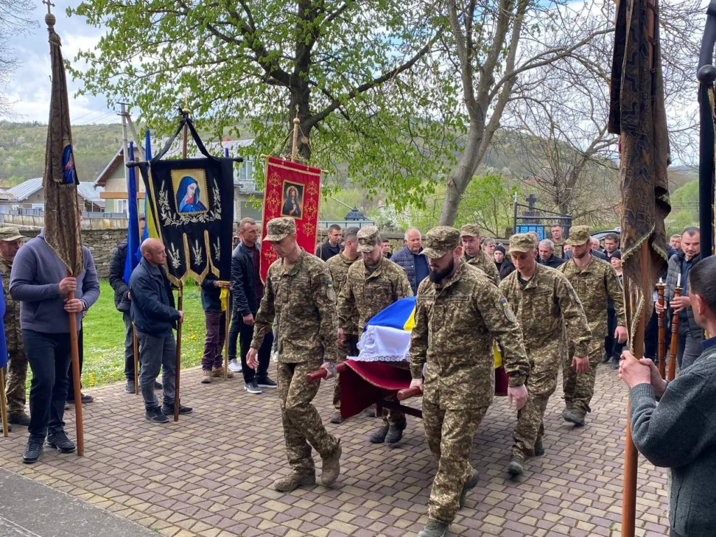 Військові несуть труну з українським прапором