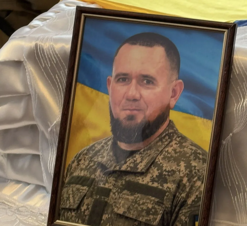 Портрет українського військового на тлі прапора