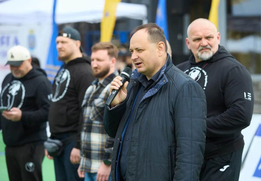 Чоловік виступає з мікрофоном на вулиці