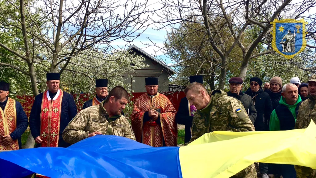 Військові та священники тримають український прапор