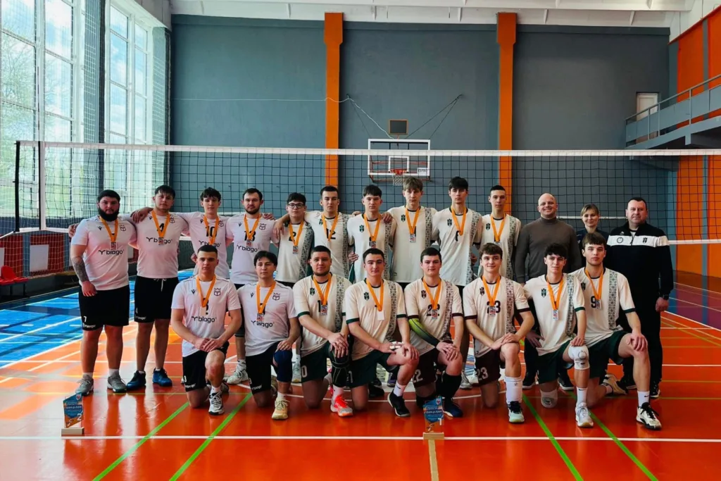 Чоловіча волейбольна команда позує в спортивному залі