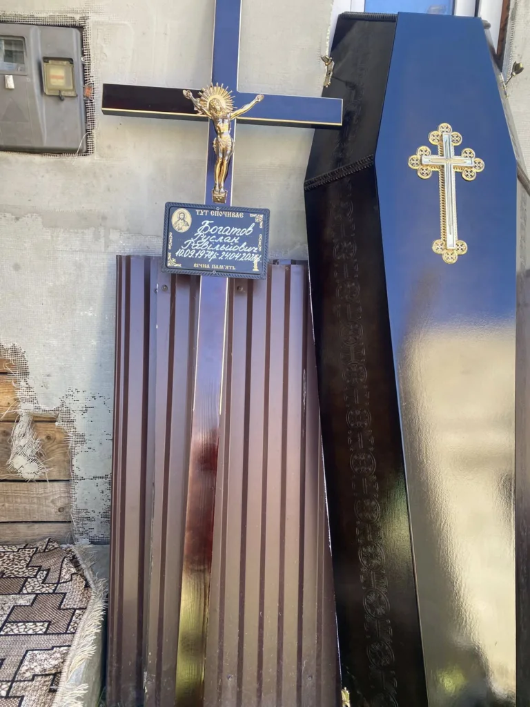 Хрест і труна поруч стіни будівлі