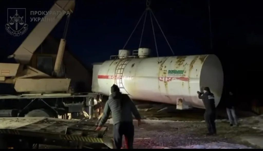 Підйом великої цистерни краном уночі